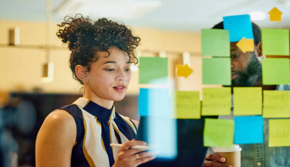 Professional woman analyzing sticky notes during a strategy session, representing growth through training